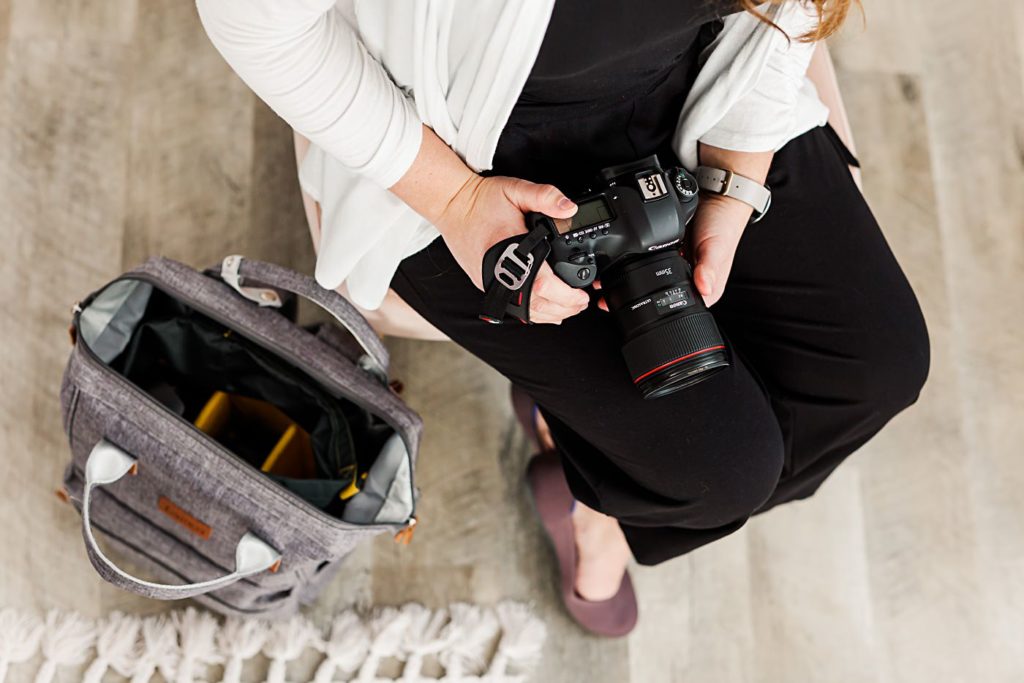 Branding Photography highlighting a wedding photographer packing a camera bag, photo of hands and camera bag