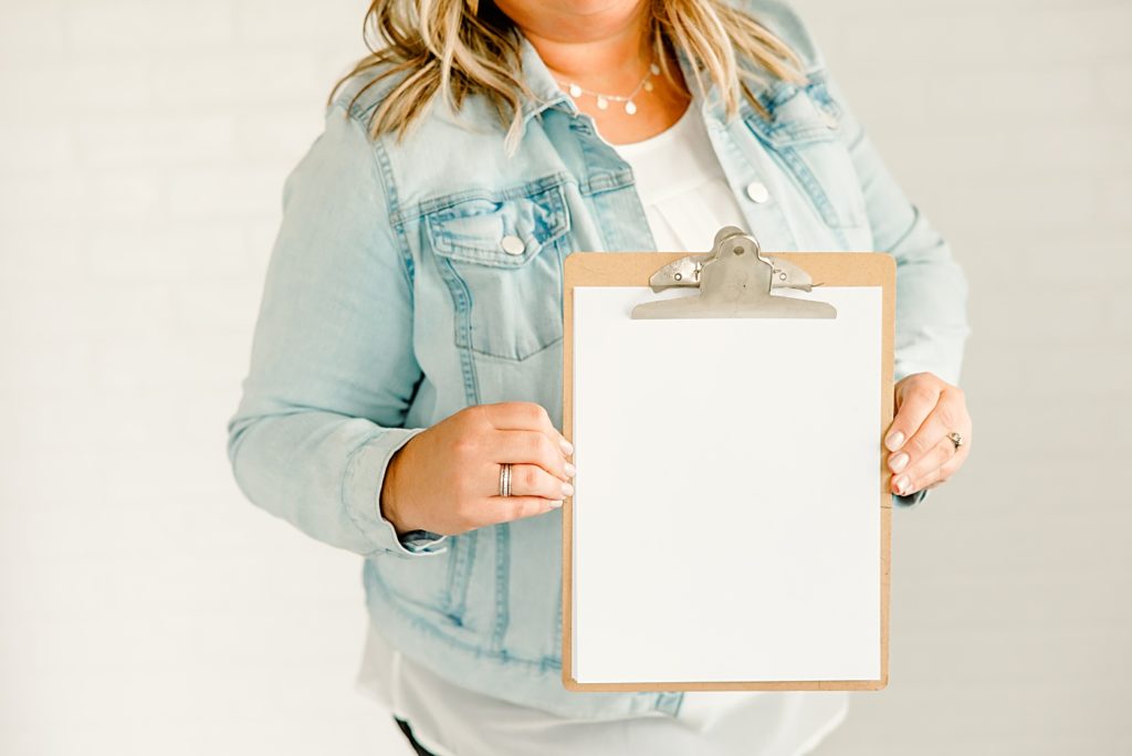Teacher influencer holding a clipboard, wearing a light jean jacket