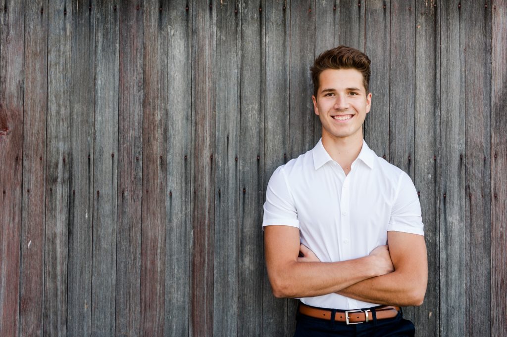 senior guy photo wearing white shirt with arms crossed