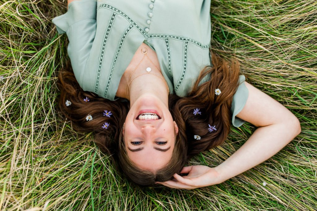 Minnesota Senior Photographer, Girl laying in grass with flowers in her hair