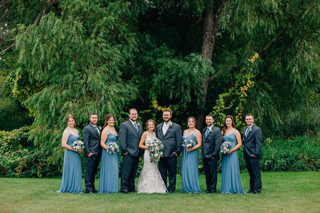 Bridal party with blue accents and wood flowers at barn at dunvilla