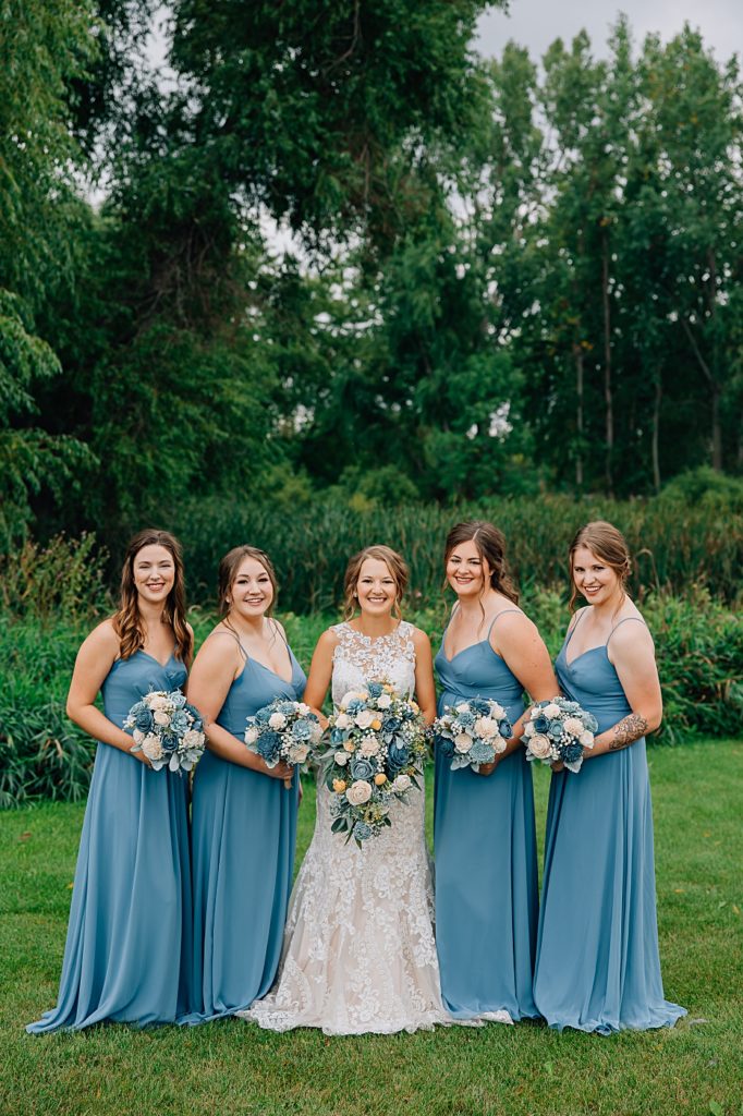 Bridesmaids wearing blue dresses at barn at dunvilla