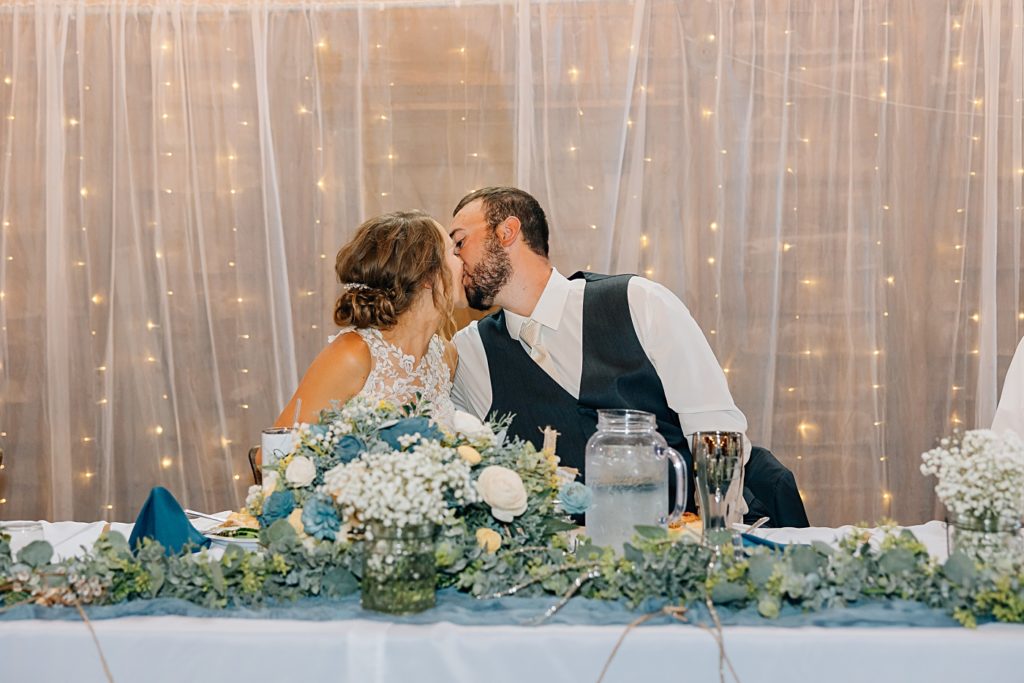 Bride and Groom kissing at head table