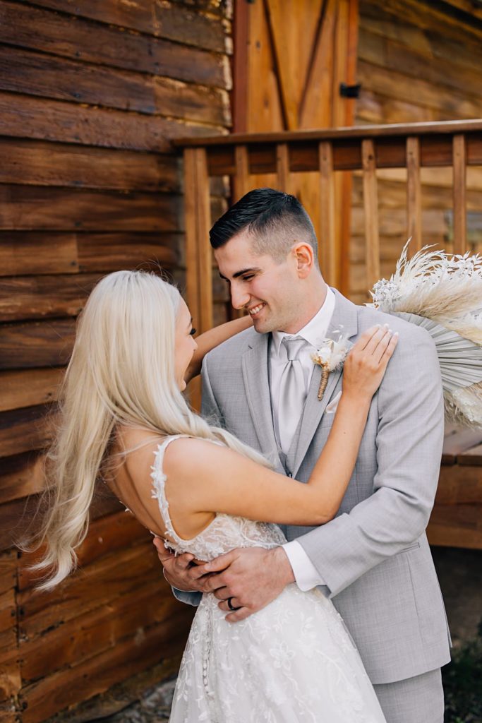 Groom dipping bride in front of rustic building at The Hitching Post