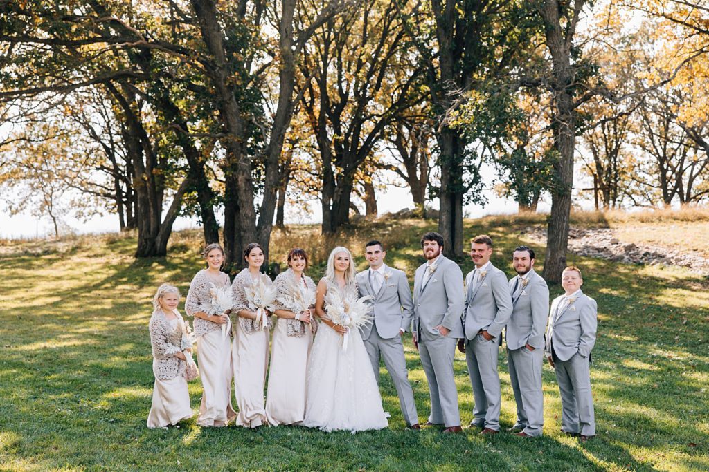 Bridal party standing in front of oak trees at the Hitching Post