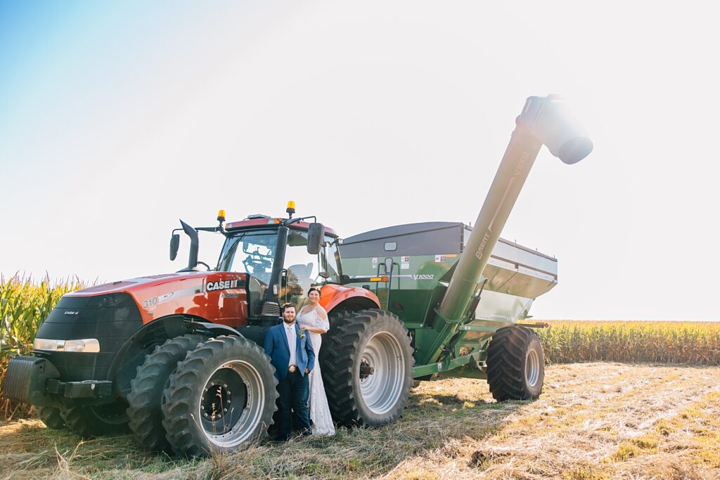 bride and groom standing with case tractor and grain cart