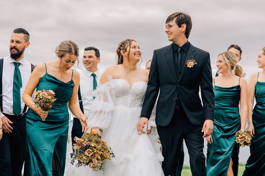 bride and groom looking at each other by their bridal party
