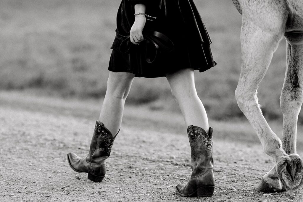 Senior Pictures with Your Horse | Senior's feet alongside horse hooves walking away from photographer