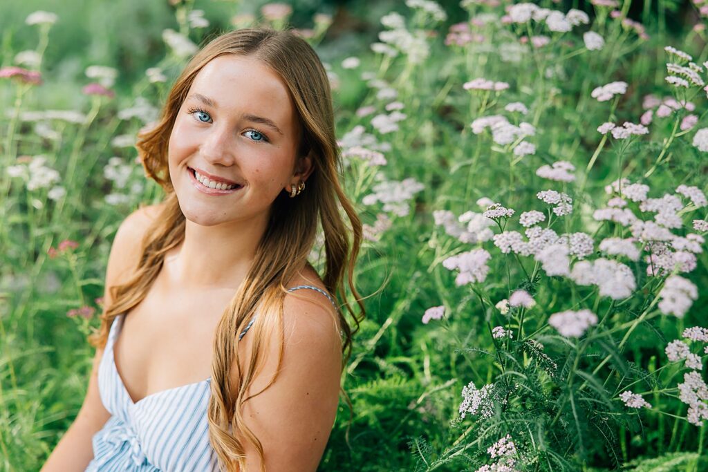 Minnesota high school senior posed next to a hedge of wildflowers
