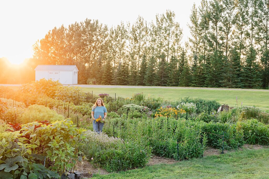 flower farmer standing in her field wearing her uniform during a brand photography session in hawley, minnesota