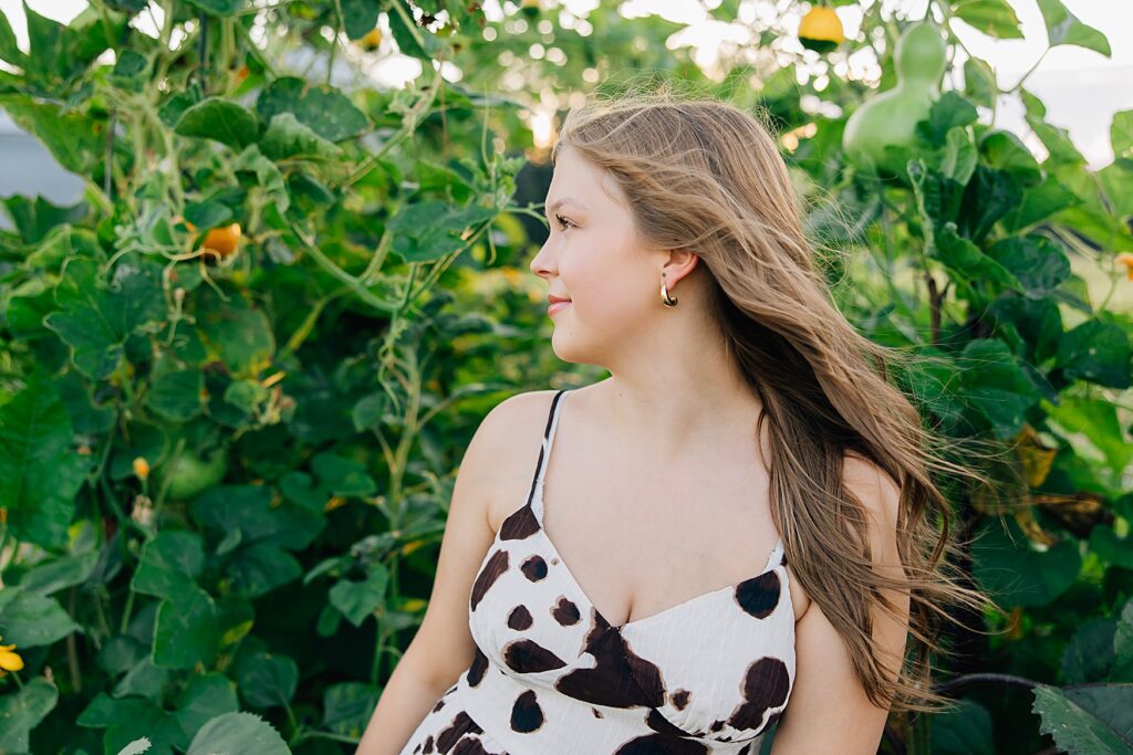 Minnesota high school senior standing in front of green archway. Ideas for planning your Minnesota senior session