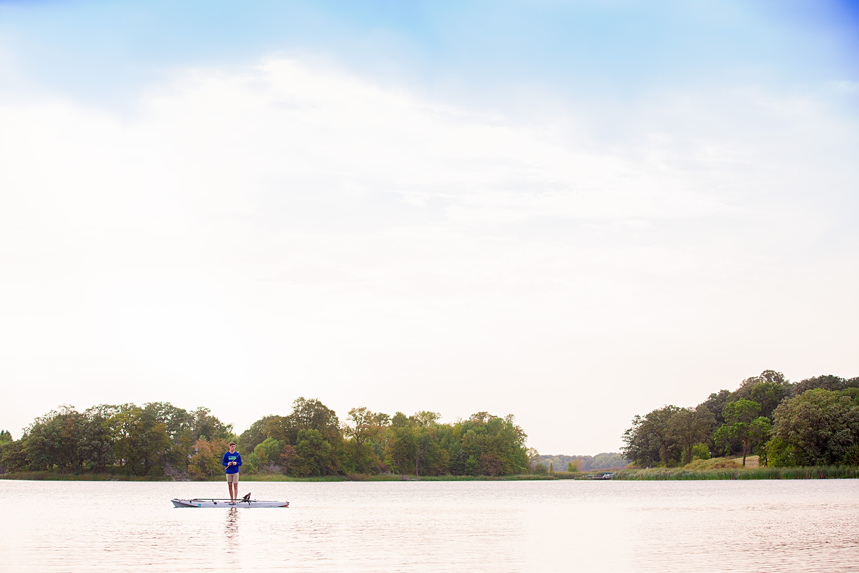 senior fishing off a canoe in the Detroit Lakes, MN area