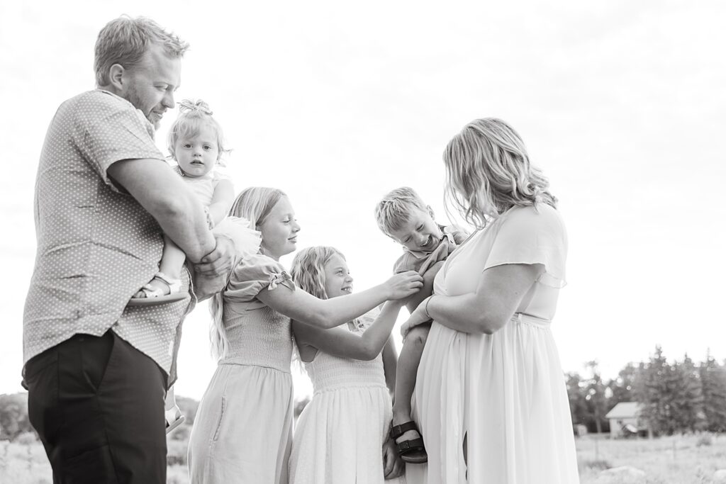 Family photo of family interacting and giggling at each other in Detroit Lakes, MN