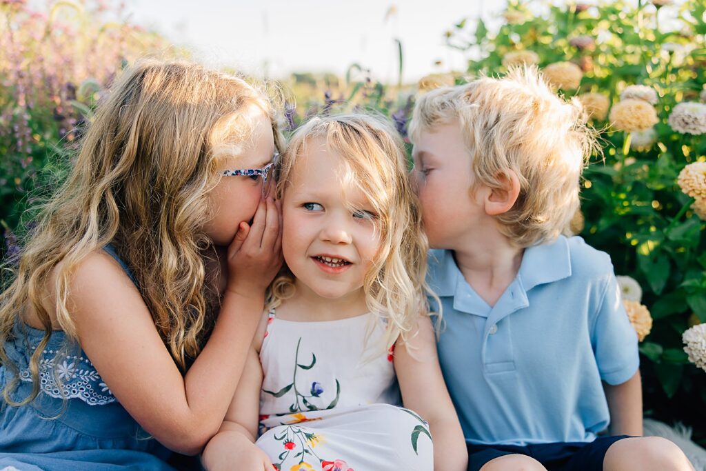 Family photo of kids snuggling together in a flower field in Detroit Lakes, Minnesota.