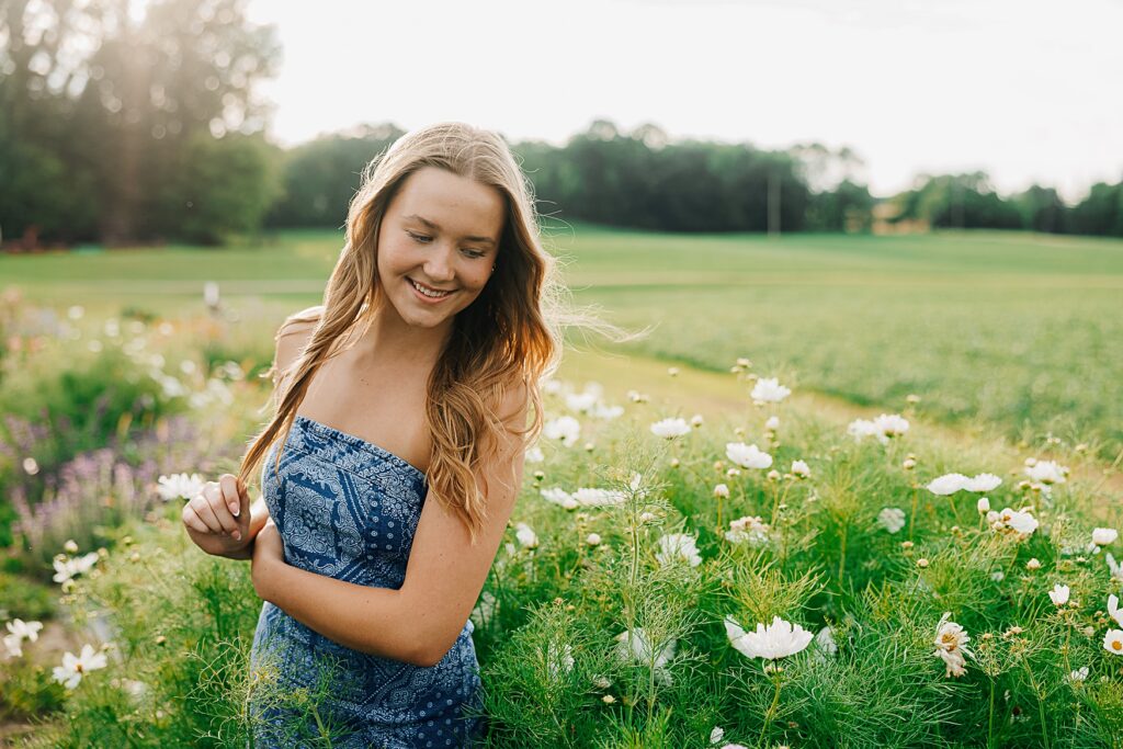 Senior standing in a field of flowers.