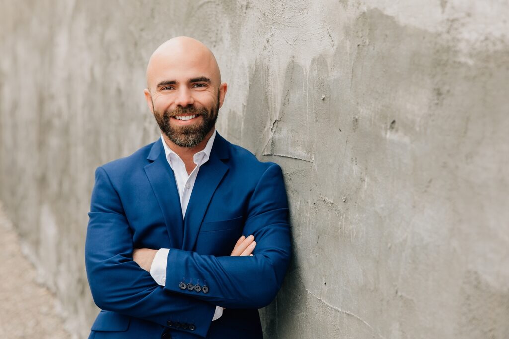 Downtown Detroit Lakes Lunch Break Headshot | guy leaning against wall in blue suit